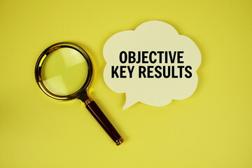Objective Key Results text with speech bubble and magnifying glass on yellow background