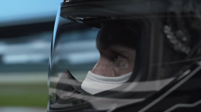 Intense video of a helmeted driver on the track, sharp focus, high-speed action captured.