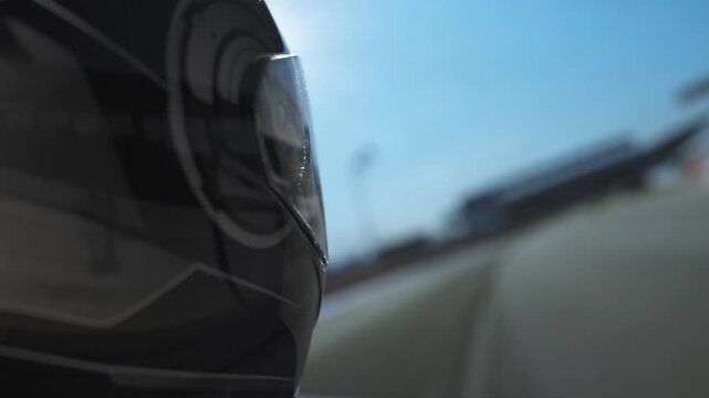 Motorsport athlete filmed during high-speed racing, full helmet protection, extreme focus.