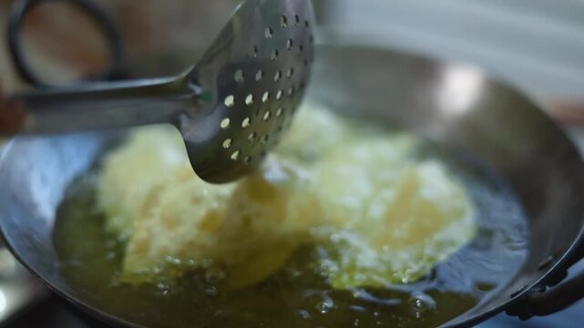 Gujhiya a dessert being crispy fried in oil