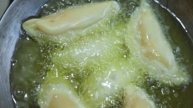Gujhiya a dessert being crispy fried in oil