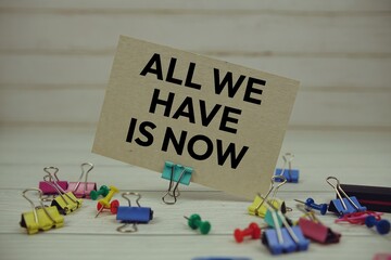 All We Have Is Now text on paper card with stationary on wooden background