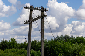 Old electricity poles with disconnected wires under a cloudy sky