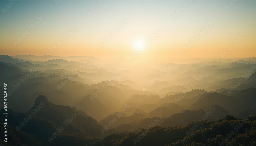 Poster Sunlight filtering over the ridges of a layered mountain range, creating a gradient of light and shadow at dusk