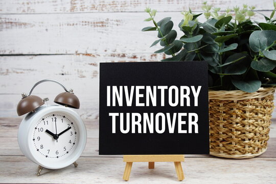 Inventory Turnover text with alarm clock on wooden background