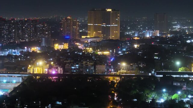 Aerial drone view of delhi city at night with buildings and metro moving by