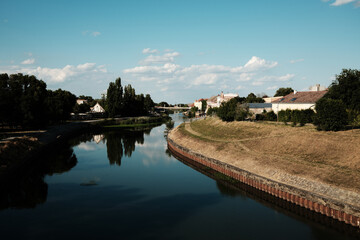 Panoramic view of the Begej River and old town buildings in Zrenjanin, Serbia, with trees and blue...