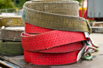 Red and brown lashing straps used to secure loads during transportation on vehicles. They are used...