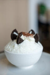 Shaved ice or Bingsu with chocolate powder and cookie on the top, served in a bowl