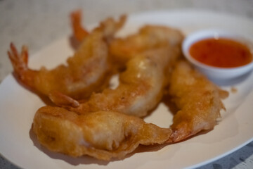 Fried shrimp served on plate with sauce