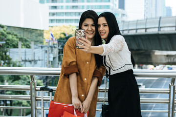 Two beautiful Asian girls take a selfie before leaving  outside the passenger terminal building