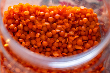Close-up of red lentils in a glass jar.  Storage concept