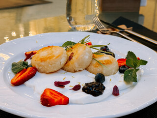 Fine dining dessert featuring fresh fruits and creamy layers on a white plate