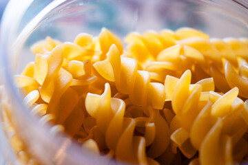 Close-up of uncooked fusilli pasta stored in the transparent glass jar