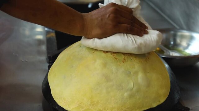 indian food restaurant paratha making on tawa 
