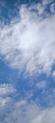 Background with clouds on blue sky. Sky view. Beautiful sunny sky. Clouds on blue sky. Sun shining through the puffy clouds.