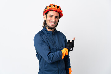 Young cyclist man isolated on white background pointing back