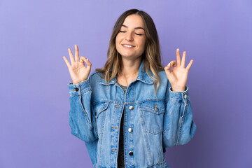 Young Romanian woman isolated on purple background in zen pose