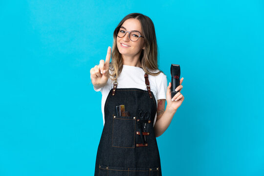 Young Romanian hairdresser woman isolated on blue background showing and lifting a finger