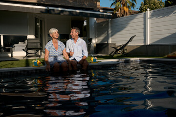 Senior couple relaxing by the poolside, enjoying retirement together