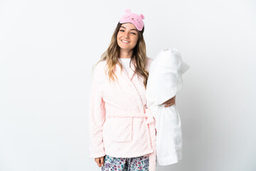 Young Romanian woman isolated on white background in pajamas and smiling a lot