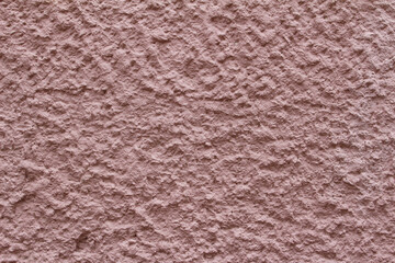 Rough surface of pink concrete wall close up background. Uneven cement wall texture.	