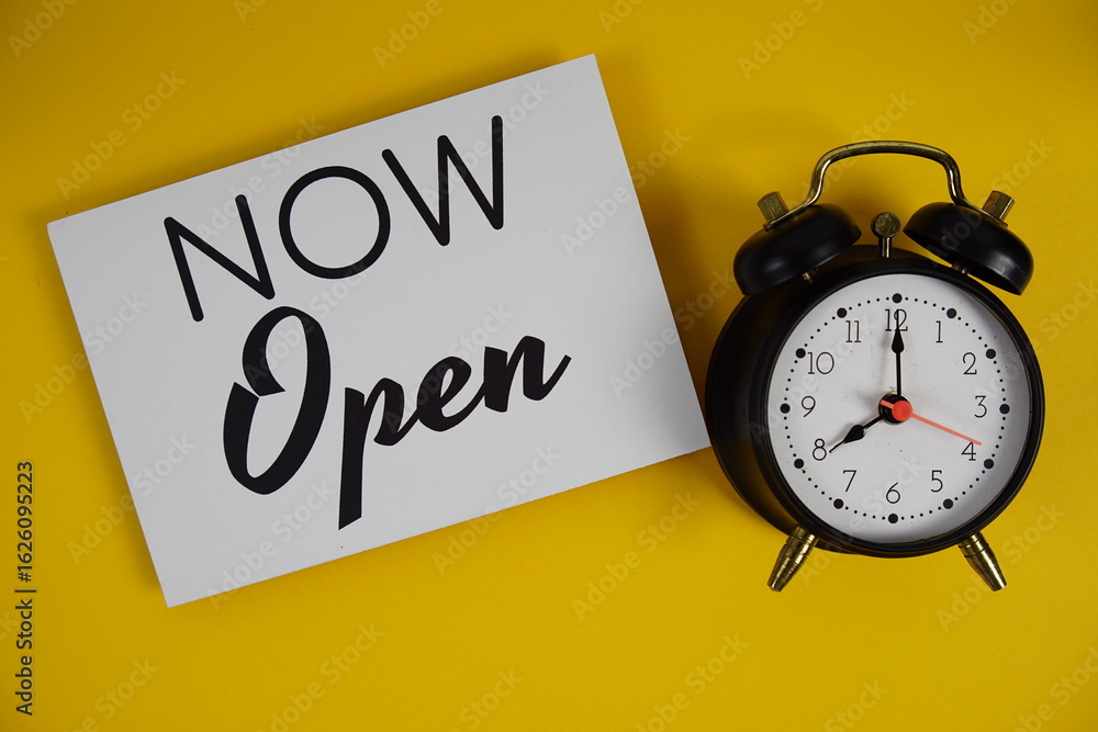Poster Now Open alphabet letters with alarm clock flat lay on yellow background