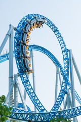 Roller coaster Ride against blue sky. Roller coaster in the amusement park. Cheerful entertainments...
