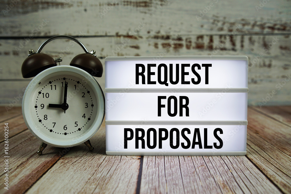 Aufkleber request for proposals text on light box with alarm clock on wooden background