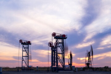 in the evening, oil pumps are running, The oil pump and the beautiful sunset reflected in the...