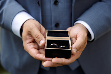 Groom Holding Wedding Rings in a Box
