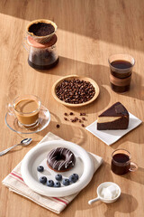Delicious Coffee Break Coffee, Cake, and Donut Delight, A cup of coffee and chocolate cake on a wooden table with coffee beans