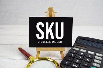 SKU Stock Keeping Unit text with magnifying glass and calculator on wooden background