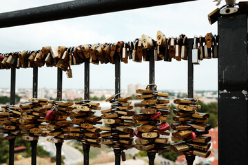 Love padlocks covering a metal fence at viewpoint of Petrovaradin Fortress overlooking Danube...