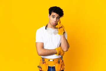 Venezuelan electrician man isolated on yellow background thinking an idea