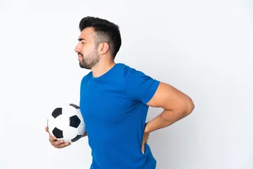 Gordijnen Handsome young football player man over isolated wall suffering from backache for having made an effort © luismolinero