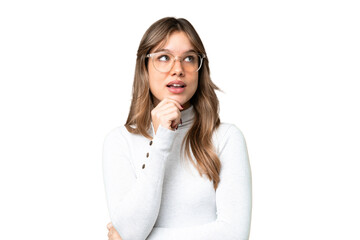 Young girl over isolated chroma key background With glasses and thinking while looking up