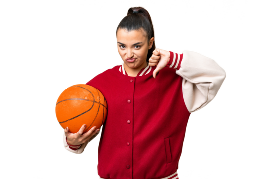 Young Woman playing basketball over isolated chroma key background showing thumb down with negative expression