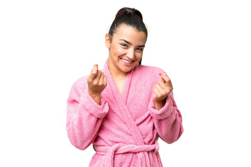 Young woman in a bathrobe over isolated chroma key background making money gesture