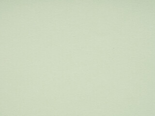 A subtle dance of light and texture on a muted sage green paper surface