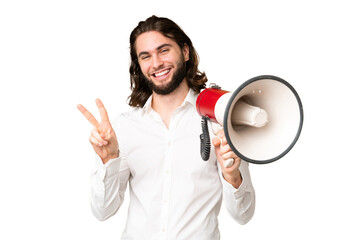Young handsome man over isolated chroma key background holding a megaphone and smiling and showing...