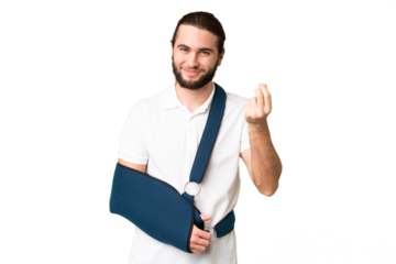 Young handsome man with broken arm and wearing a sling over isolated chroma key background making money gesture