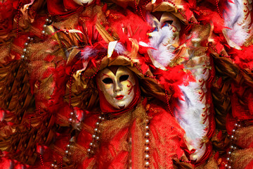 a splendid traditional mask surrounded by a red dress