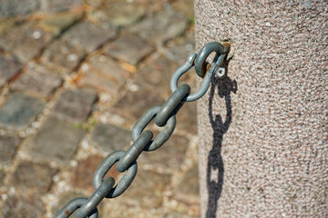 Concrete Post with Metal Hook and Attached Chain
