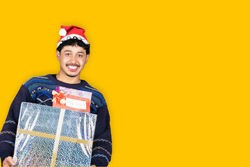 Young Asian Male Celebrating Christmas with tree, Santa Claus Cap, Sweater, Gifts in isolated background