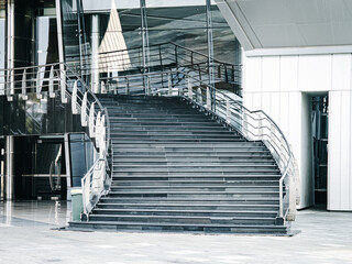 Obraz premium Wide staircase with modern steel railings in a sleek commercial building lobby, highlighting contemporary architecture, symmetry, and urban interior design.