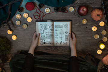 Witch Woman learns witchcraft from a the wizard's manuscript book, casts spell, sitting on the...