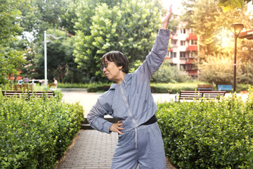 Vibrant Jchinese senior women doing preparatory exercises and stretching. Images of health,...