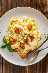 Classic creamy chicken alfredo fettuccine pasta on wooden table