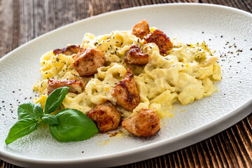 Classic creamy chicken alfredo fettuccine pasta on wooden table